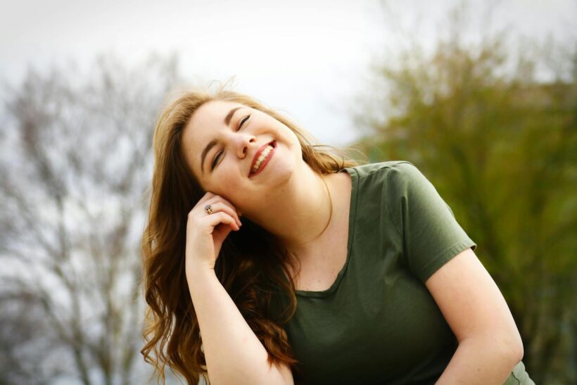 A carefree woman enjoying a sunny day outdoors, expressing pure happiness and relaxation.